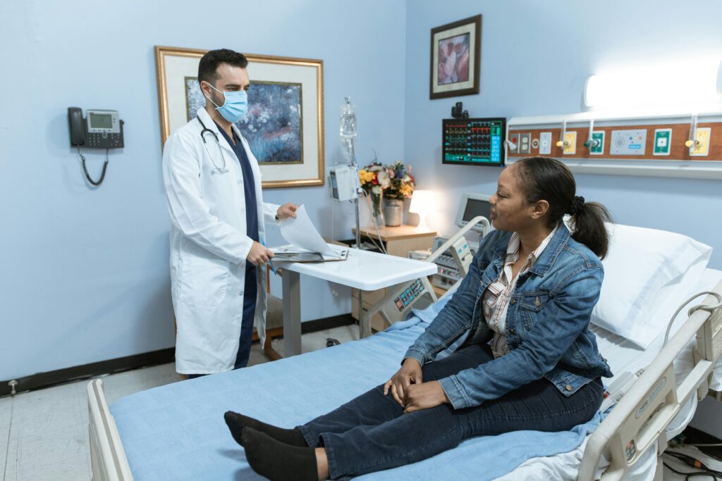 A medical professional conducts a check-up with a patient in a hospital setting.